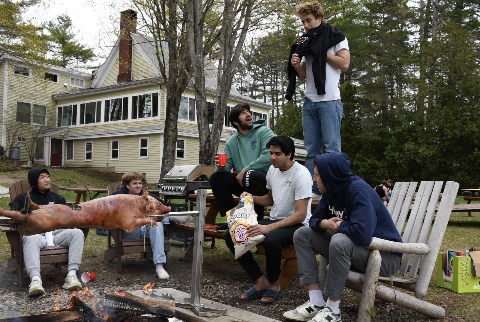 Brothers around a fire pit outside the Endicott lodge.