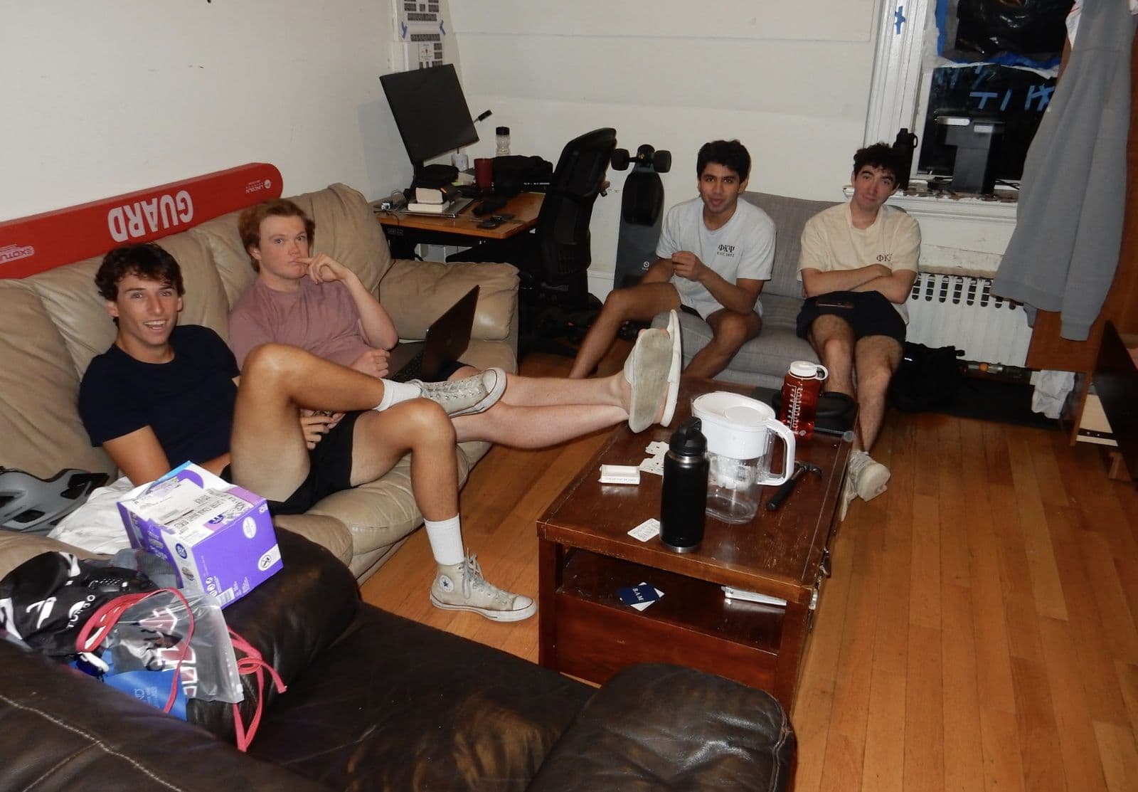 Brothers sprawled across couches in a common room.