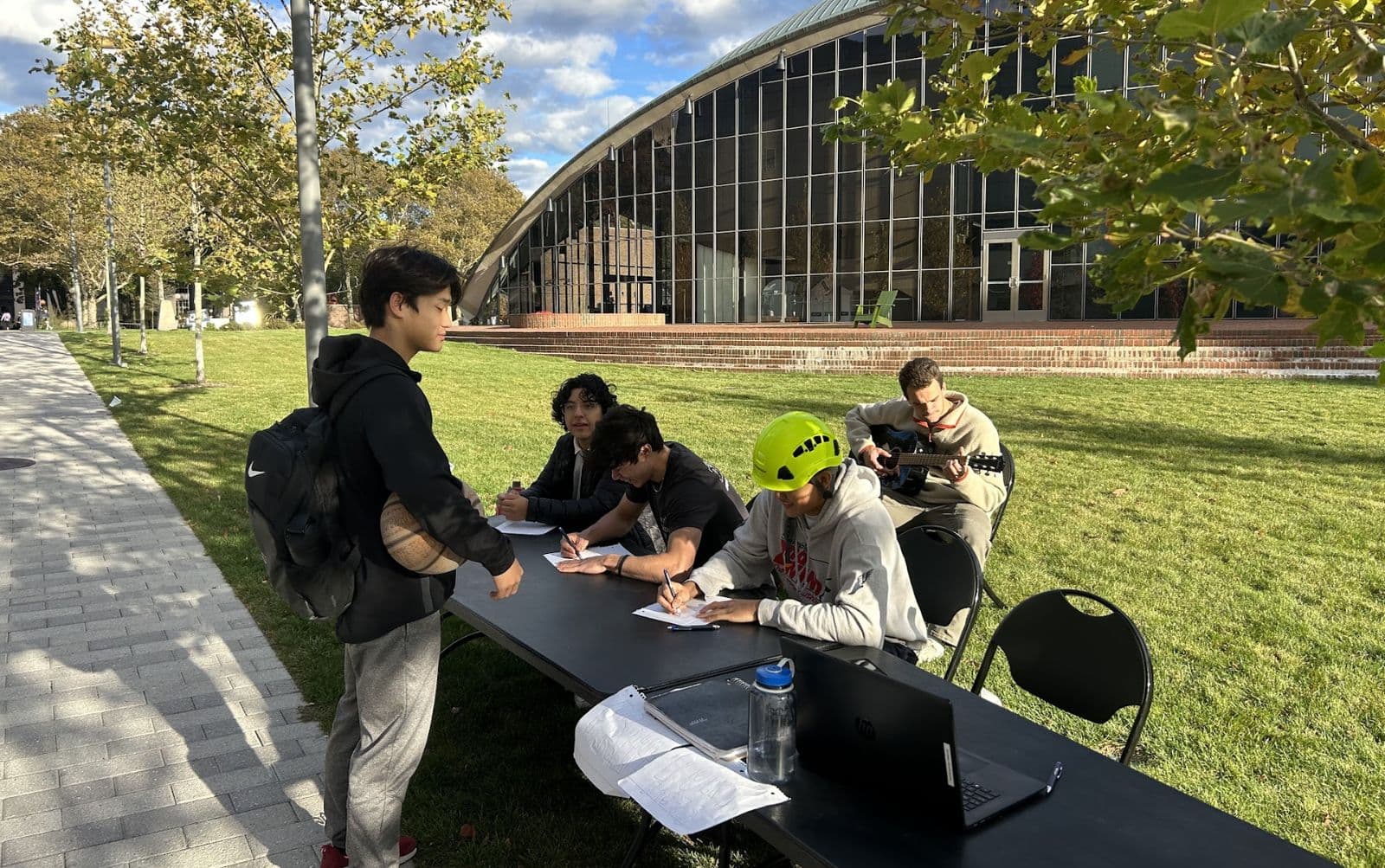 Brothers tabling for a campus fundraiser on the lawn outside Kresge.