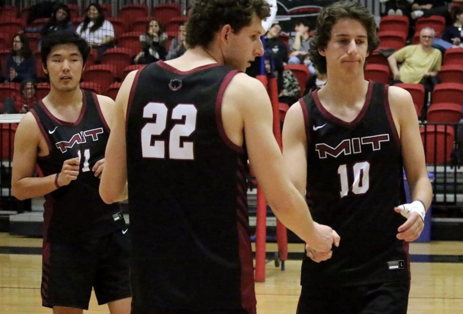MIT volleyball players on court between points.